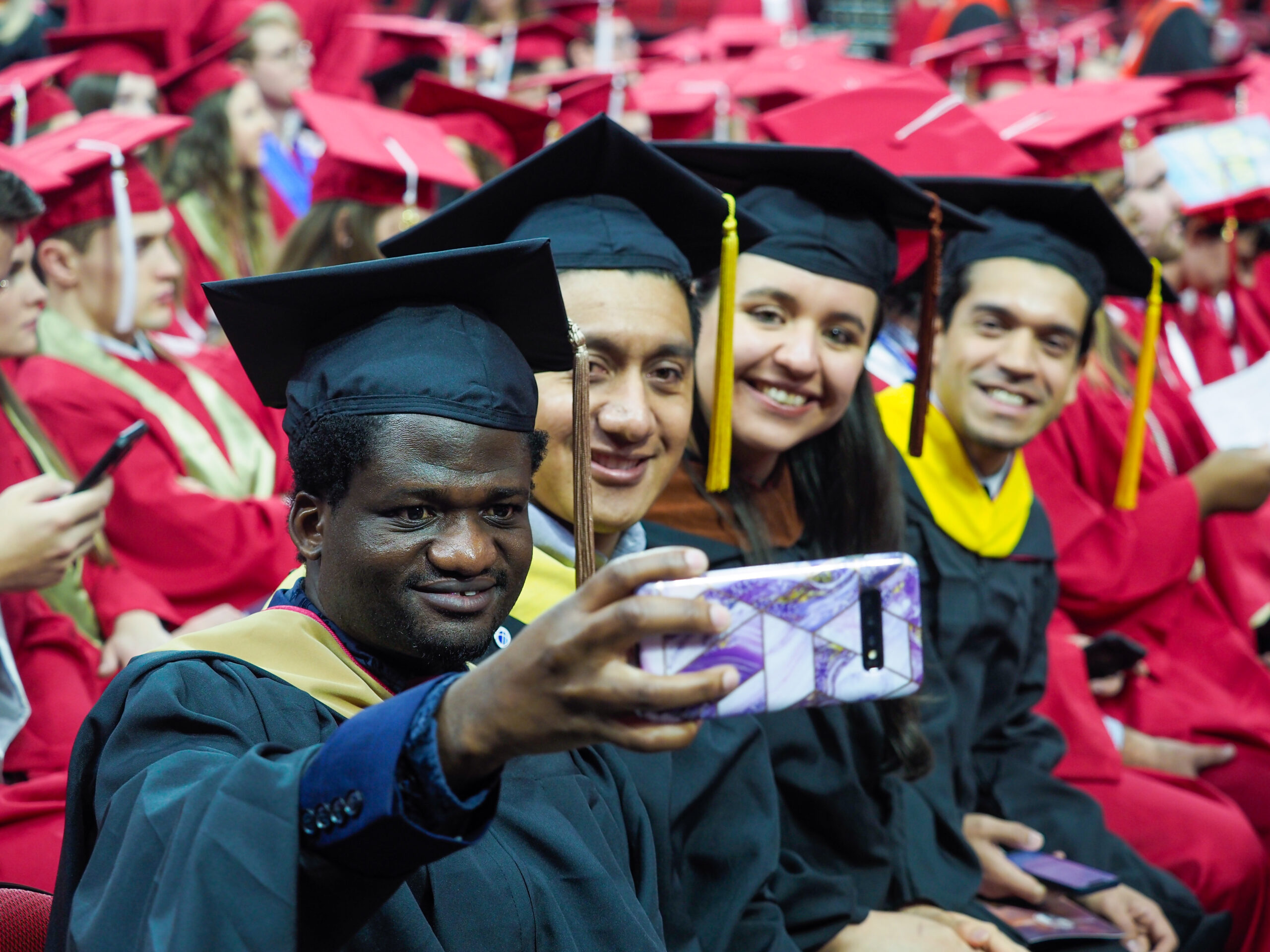 A group of graduates take a selfie at Fall 2022 Commencement.