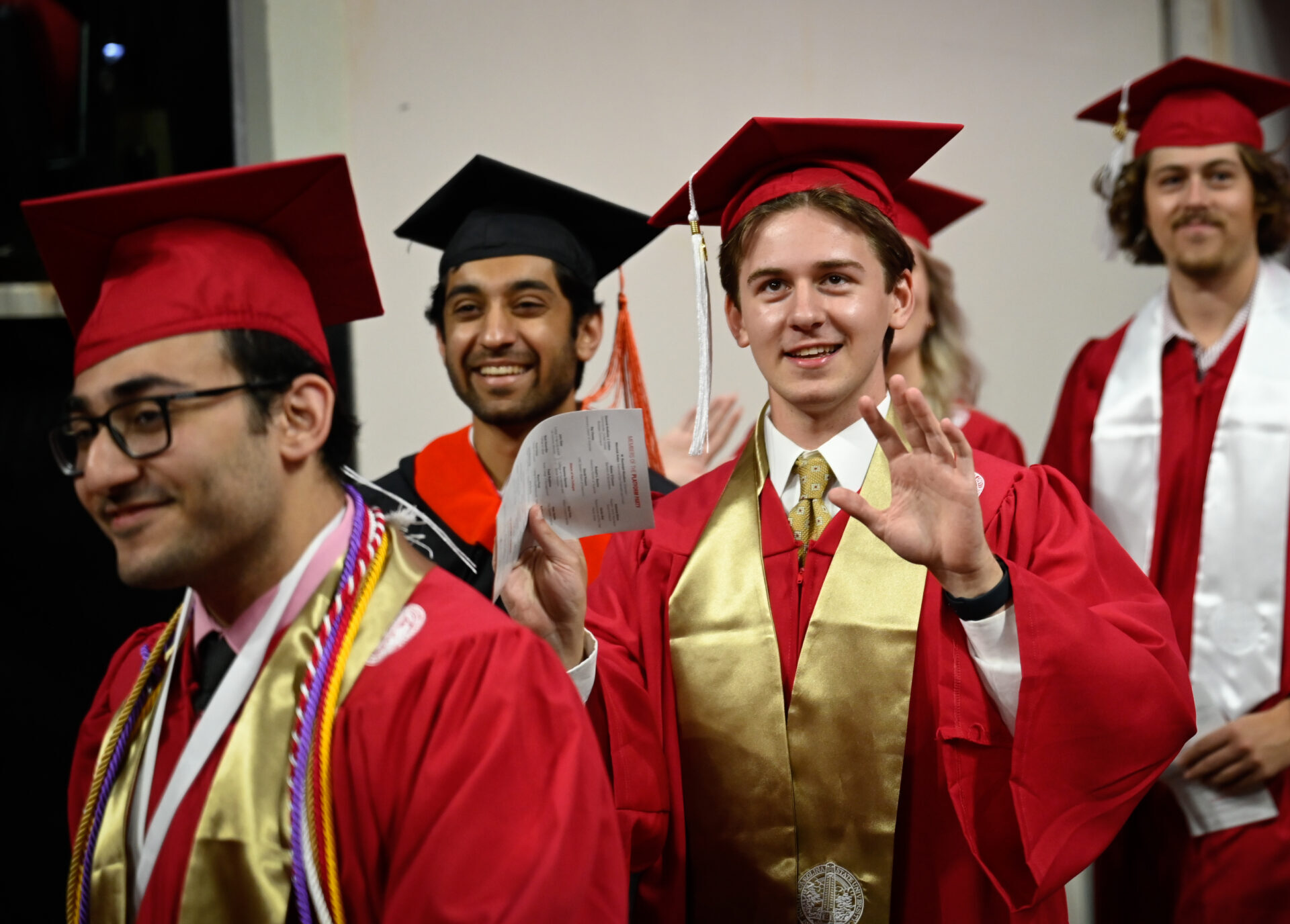 An undergraduate student waves to the crowd at commencement at PNC arena. Photo by Marc Hall